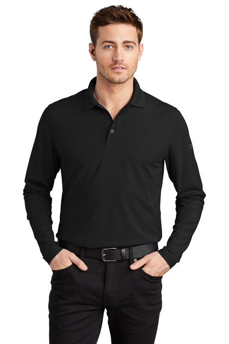 Male model wearing OGIO Caliber2.0 Long Sleeve OG105 polo in black, 5oz poly pique with stay-cool wicking, 3-button.